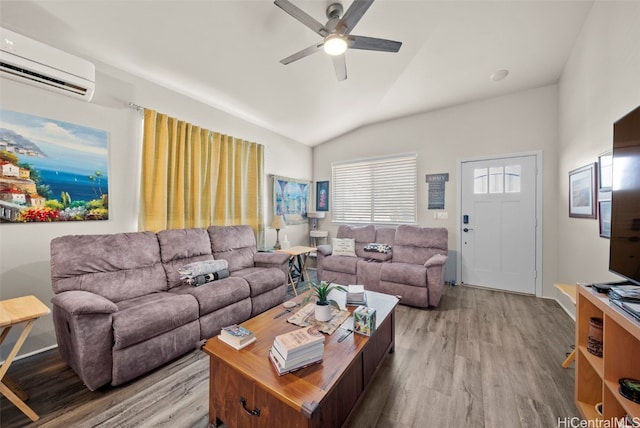 living room with a wall mounted air conditioner, lofted ceiling, ceiling fan, and light hardwood / wood-style floors