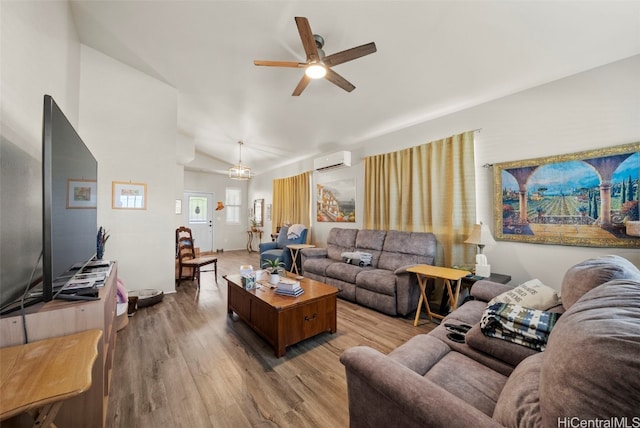 living room featuring light wood-type flooring, vaulted ceiling, a wall mounted air conditioner, and ceiling fan with notable chandelier