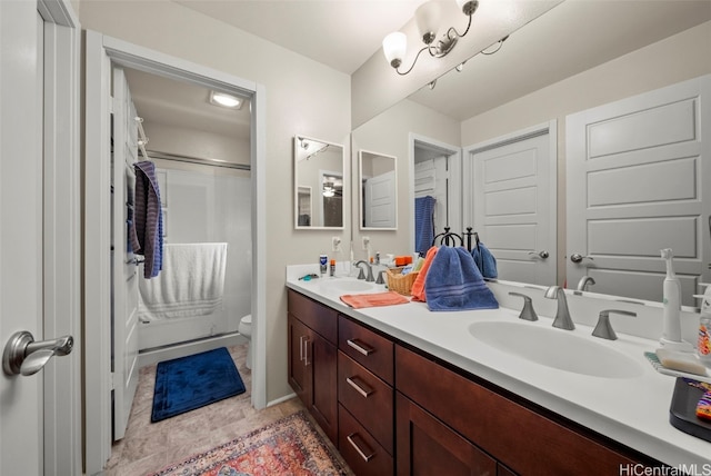 bathroom with toilet, walk in shower, vanity, and tile patterned flooring