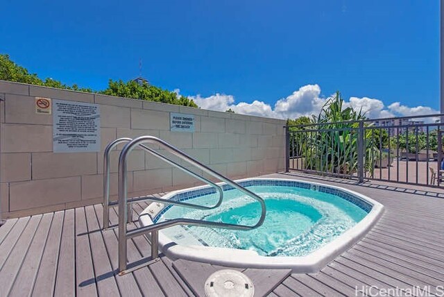 view of swimming pool featuring a hot tub