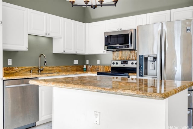 kitchen with white cabinetry, light stone countertops, stainless steel appliances, and sink