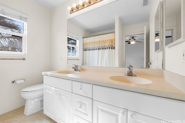 bathroom featuring vanity, toilet, a wealth of natural light, and tile patterned flooring