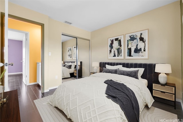 bedroom with dark wood-type flooring and a closet