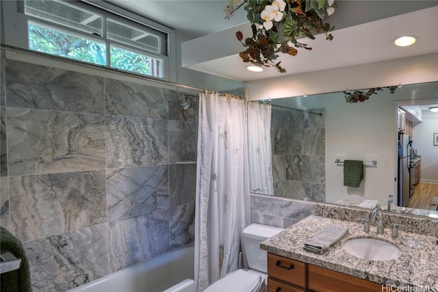 full bathroom featuring vanity, shower / tub combo, toilet, and plenty of natural light