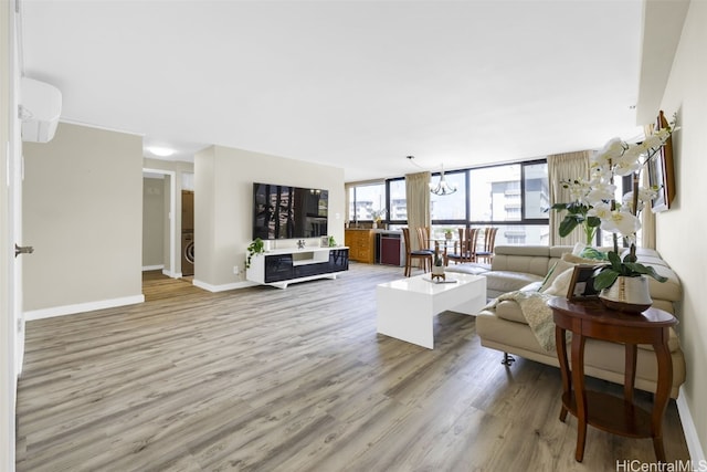 living room featuring light wood-type flooring and floor to ceiling windows