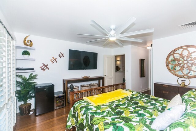 bedroom with ceiling fan, dark hardwood / wood-style flooring, and black fridge