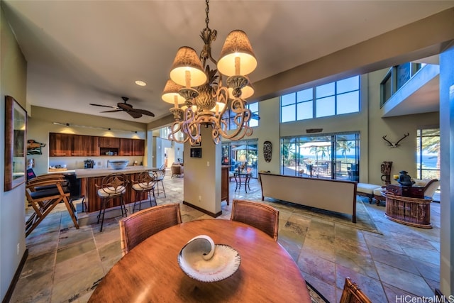 dining space with ceiling fan with notable chandelier and plenty of natural light