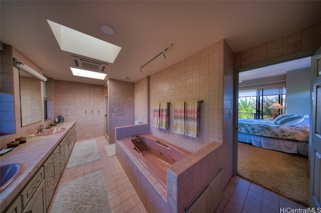 bathroom featuring vanity, tiled bath, tile patterned floors, and tile walls