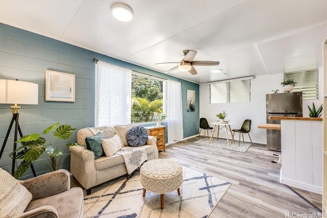 living room with ceiling fan and light hardwood / wood-style flooring