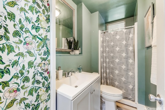 bathroom featuring vanity, toilet, and walk in shower