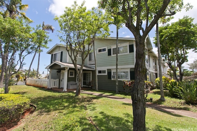 rear view of property featuring covered porch and a yard