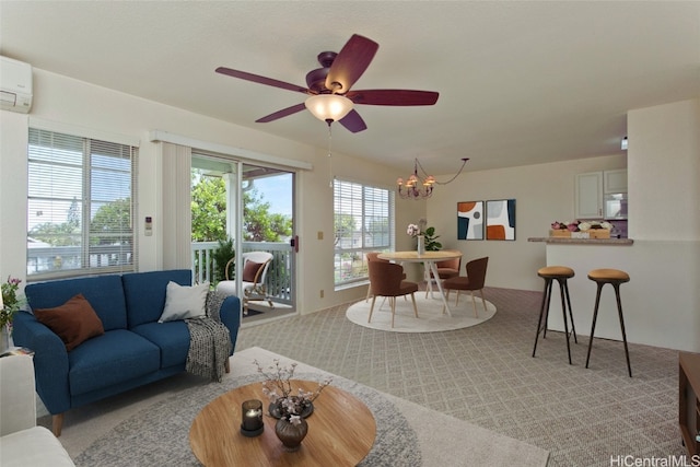 living area with ceiling fan with notable chandelier, light colored carpet, and a wall mounted AC