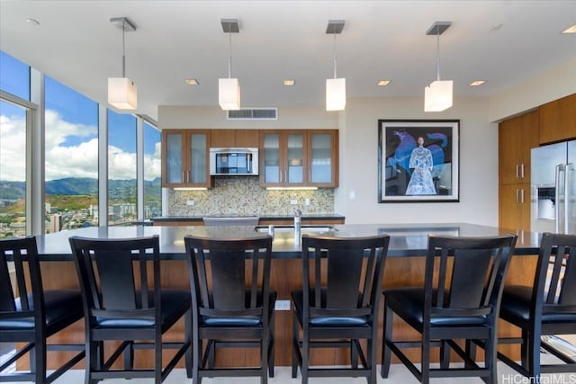 bar with a mountain view, tasteful backsplash, pendant lighting, and a wealth of natural light