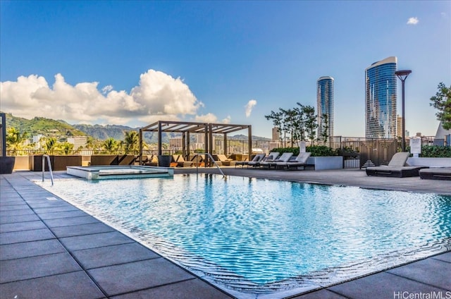 view of swimming pool with a hot tub and a patio