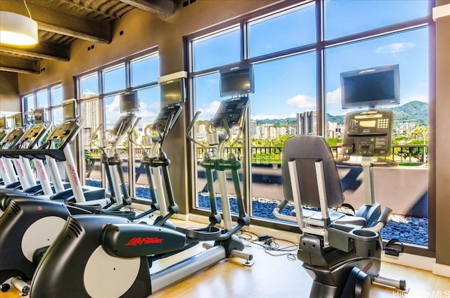 exercise room with wood ceiling and wood-type flooring