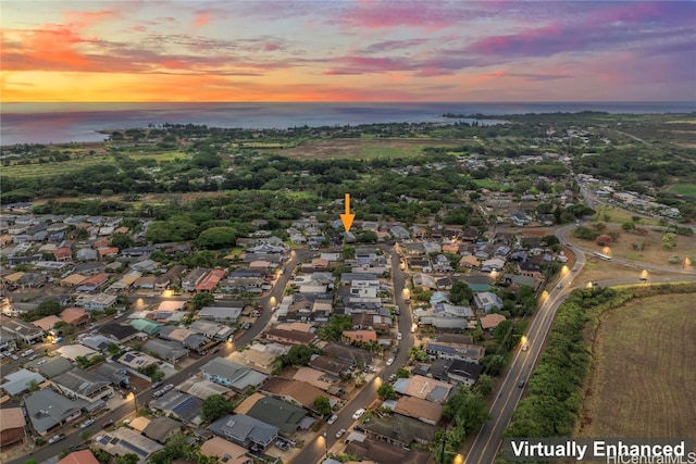 aerial view at dusk featuring a water view