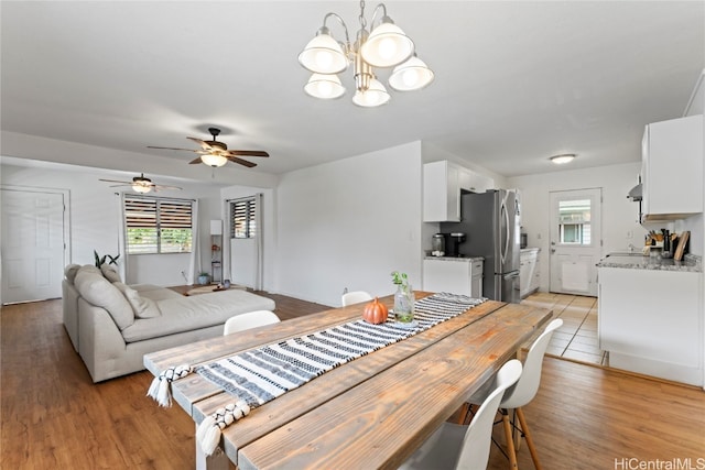 dining area featuring ceiling fan with notable chandelier and light wood-type flooring