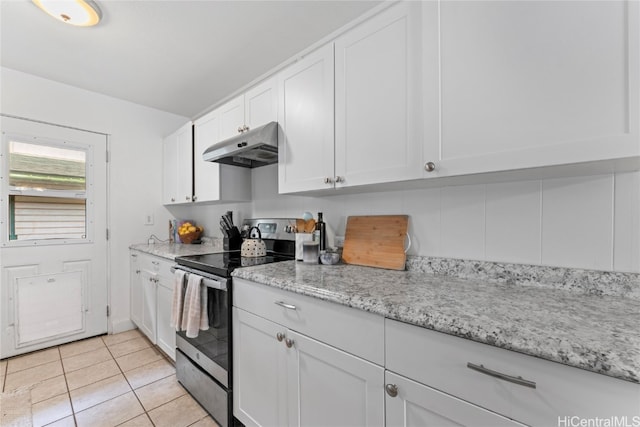 kitchen with white cabinets, light stone counters, light tile patterned floors, and electric stove