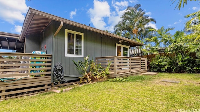 view of property exterior featuring a wooden deck and a yard