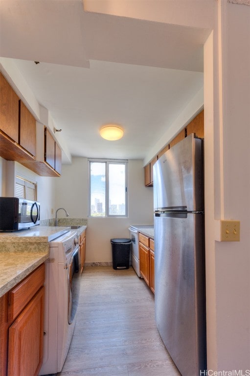 kitchen with light hardwood / wood-style flooring, stainless steel appliances, and sink