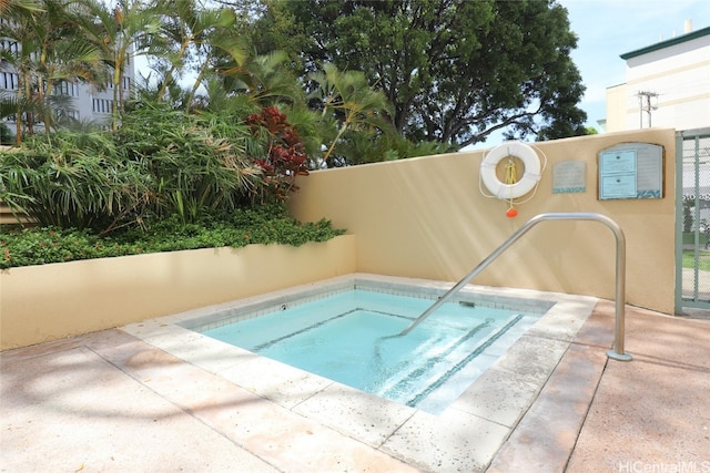 view of swimming pool with a hot tub and a patio