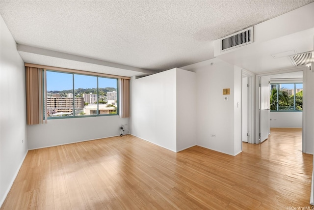 1314 Kalakaua Ave Unit 513, Honolulu, HI 96826 - spare room with light wood finished floors, healthy amount of natural light, and a textured ceiling
