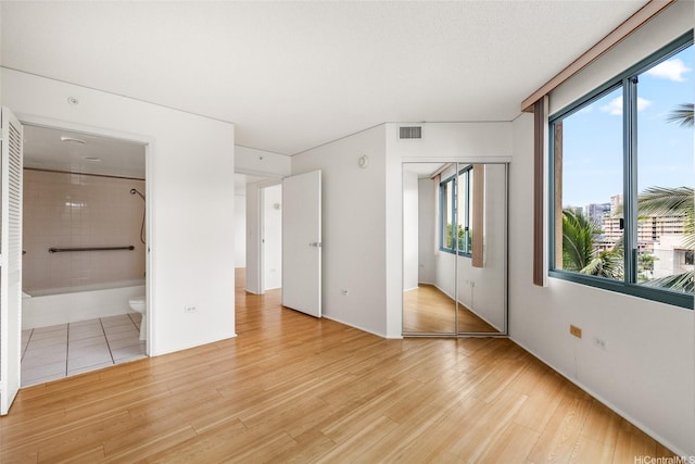 1314 Kalakaua Ave Unit 513, Honolulu, HI 96826 - unfurnished bedroom featuring a closet, light wood-style flooring, and ensuite bathroom