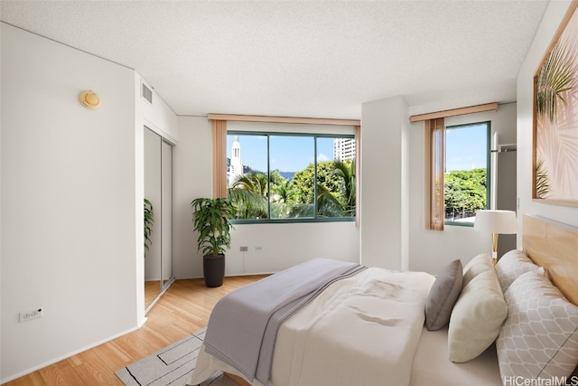 bedroom featuring a textured ceiling and light wood-type flooring