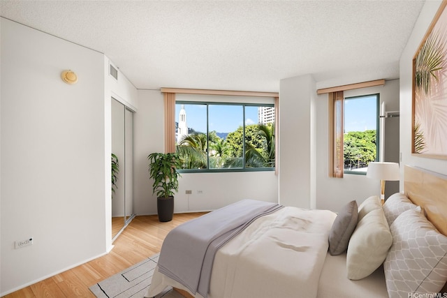 1314 Kalakaua Ave Unit 513, Honolulu, HI 96826 - bedroom featuring light wood-style floors and a textured ceiling