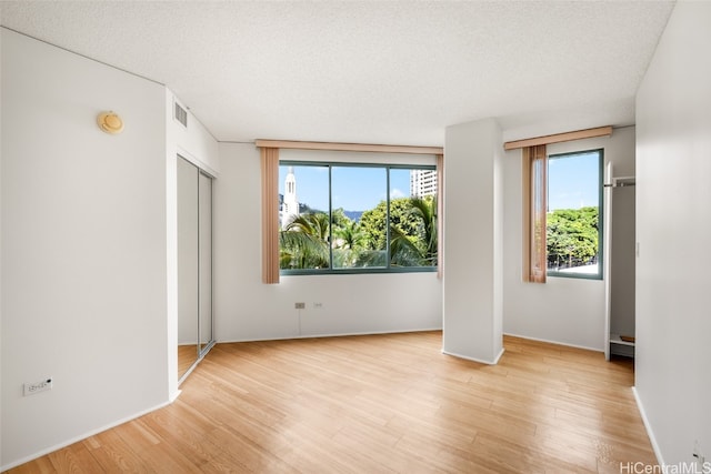 unfurnished bedroom featuring light hardwood / wood-style floors and a textured ceiling