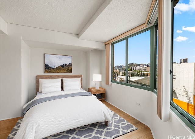 bedroom with a textured ceiling and light wood-type flooring