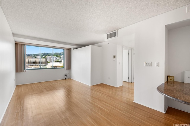 1314 Kalakaua Ave Unit 513, Honolulu, HI 96826 - spare room with light wood-type flooring and a textured ceiling