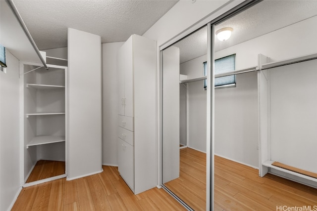 walk in closet with hardwood / wood-style flooring