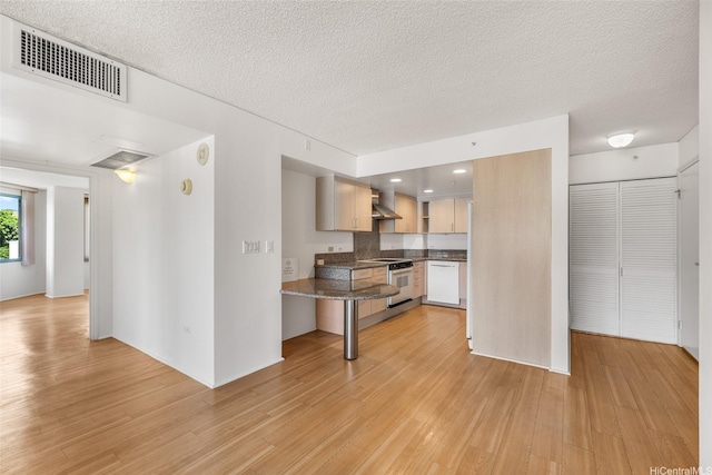 1314 Kalakaua Ave Unit 513, Honolulu, HI 96826 - kitchen with white appliances, wall chimney exhaust hood, light wood-type flooring, dark countertops, and a textured ceiling