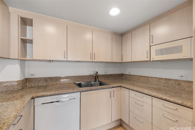 kitchen with sink, light brown cabinetry, and white appliances