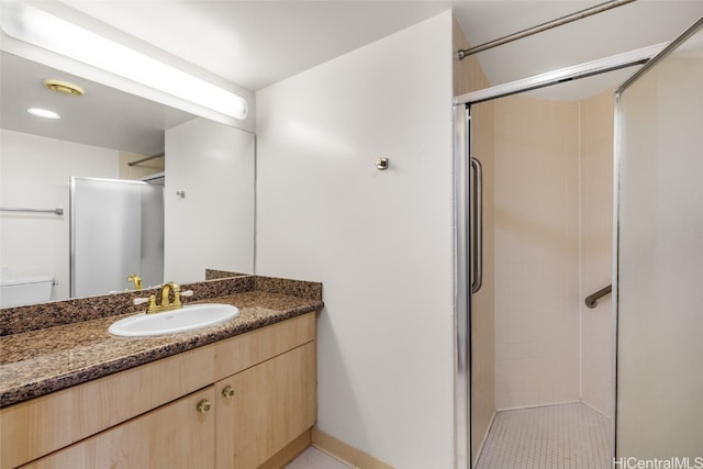 bathroom featuring a shower with door, tile patterned floors, and vanity