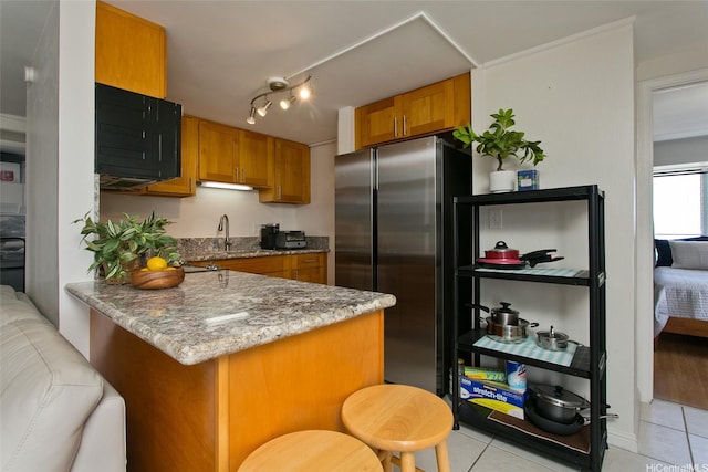 2525 Date St Unit 3706, Honolulu, HI 96826 - kitchen featuring freestanding refrigerator, light tile patterned flooring, a peninsula, and brown cabinetry