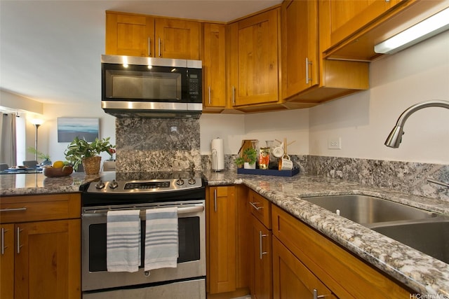 2525 Date St Unit 3706, Honolulu, HI 96826 - kitchen featuring appliances with stainless steel finishes, a sink, brown cabinets, and stone counters