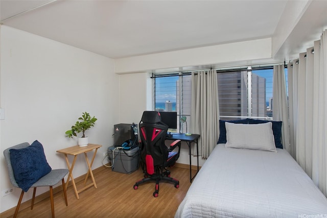 bedroom with baseboards and wood finished floors