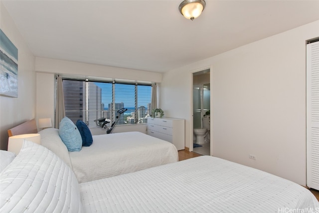 bedroom with a closet, ensuite bathroom, and hardwood / wood-style floors