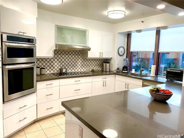 kitchen featuring white cabinetry, black electric cooktop, double oven, and sink