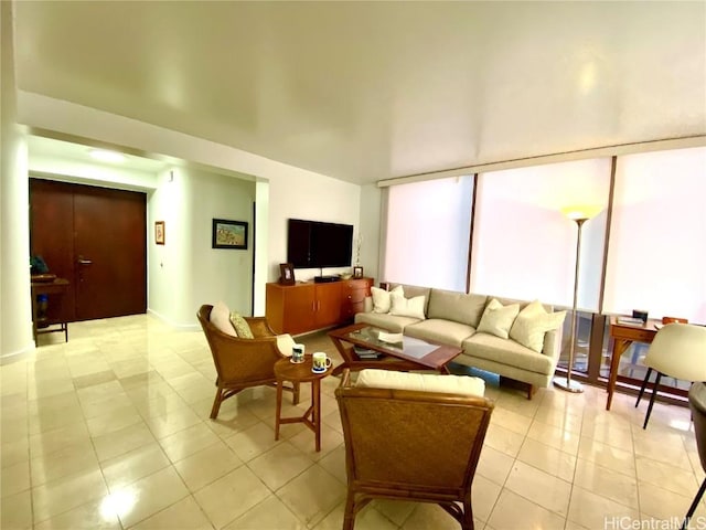 tiled living room featuring floor to ceiling windows