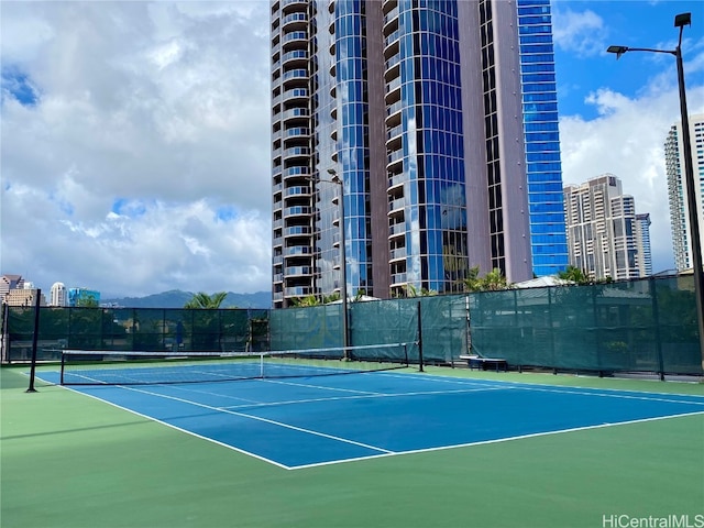 view of tennis court featuring basketball hoop