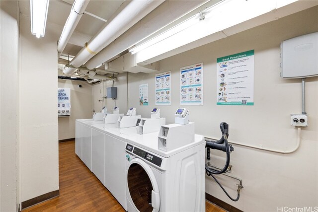 clothes washing area featuring dark hardwood / wood-style flooring and washing machine and clothes dryer