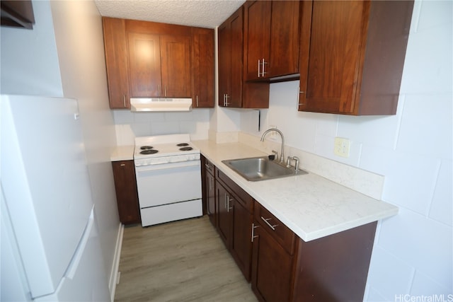 kitchen featuring light hardwood / wood-style flooring, backsplash, sink, a textured ceiling, and white appliances