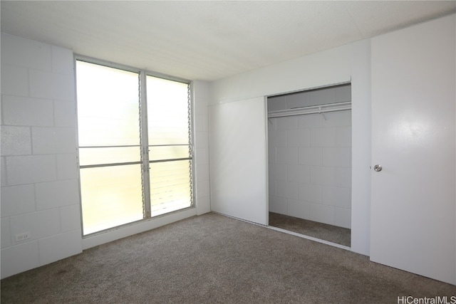 unfurnished bedroom with a closet and carpet flooring