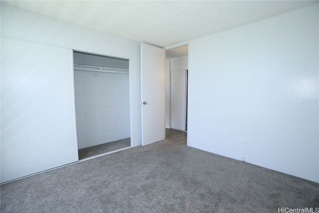 unfurnished bedroom with a closet and carpet floors