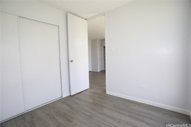 unfurnished bedroom with a closet and hardwood / wood-style flooring