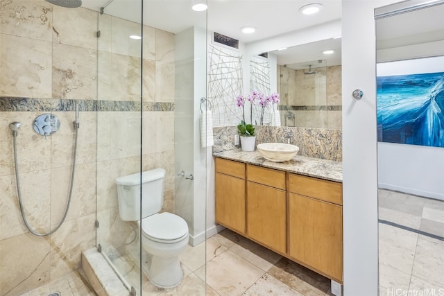 full bath featuring tile walls, tiled shower, vanity, and toilet