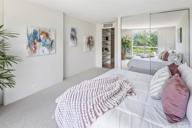 bedroom with floor to ceiling windows and light carpet